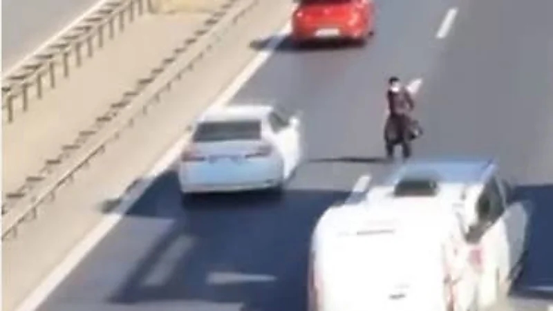 مشهد يحبس الأنفاس لشخص يتخطى طريق سريع بطريقة غريبة