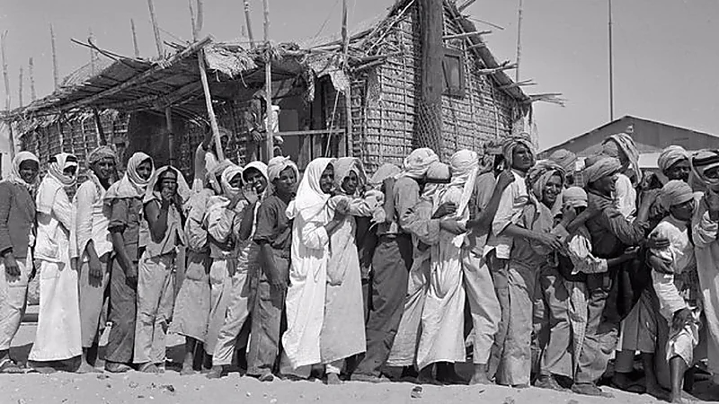 صورتان قديمتان لموظفين يصطفون عند نافذة تسليم الرواتب بأرامكو