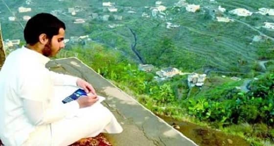 صورة ساحرة لطالب يذاكر دروسه أعلى قمم الجبال