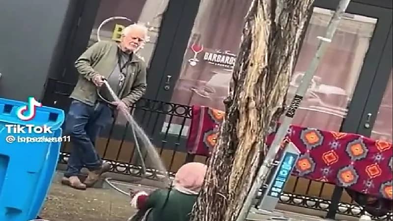 شاهد .. أمريكي يرش مشردة بالماء جلست أمام محله