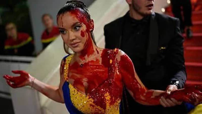 شاهد.. امرأة ترتدي العلم الأوكراني تقتحم كان السينمائي وتسكب دماء على نفسها