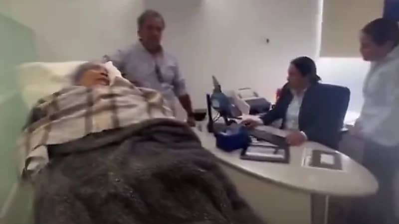 تعنت موظفة يجبر عجوز على الذهاب لبنك علي سرير مستشفى ..فيديو