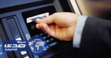 عامل يعلق داخل ماكينة صراف آلي