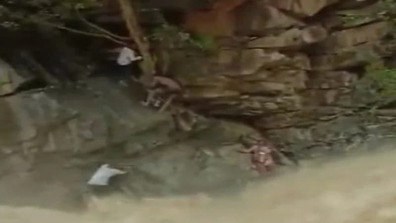 شاهد.. لحظة إنقاذ سيدة محاصرة مع طفلها بسبب تدفق شلالات 